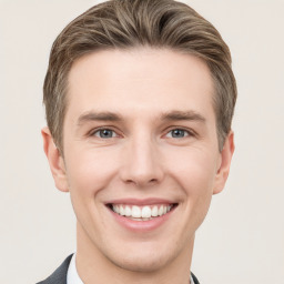 Joyful white young-adult male with short  brown hair and grey eyes