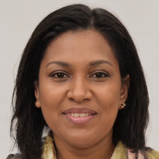 Joyful black adult female with long  brown hair and brown eyes