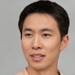 Joyful asian young-adult male with short  brown hair and brown eyes