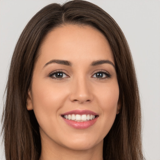 Joyful white young-adult female with long  brown hair and brown eyes