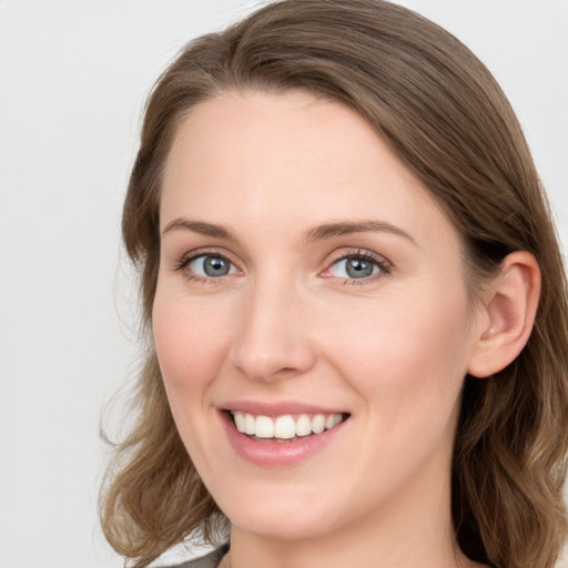 Joyful white young-adult female with long  brown hair and blue eyes