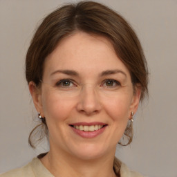 Joyful white adult female with medium  brown hair and grey eyes