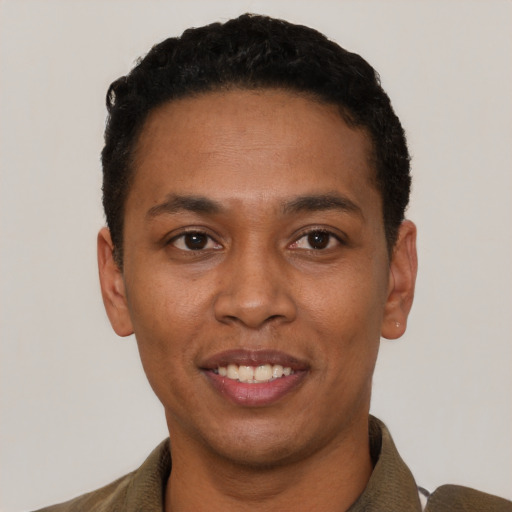 Joyful black young-adult male with short  black hair and brown eyes