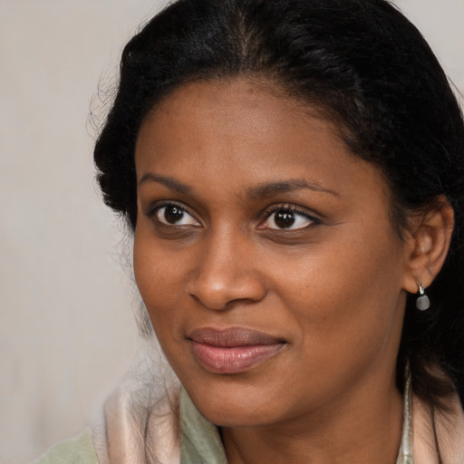 Joyful black young-adult female with long  brown hair and brown eyes