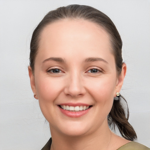 Joyful white young-adult female with medium  brown hair and grey eyes