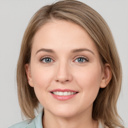 Joyful white young-adult female with medium  brown hair and blue eyes