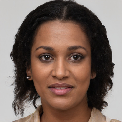 Joyful black young-adult female with medium  brown hair and brown eyes