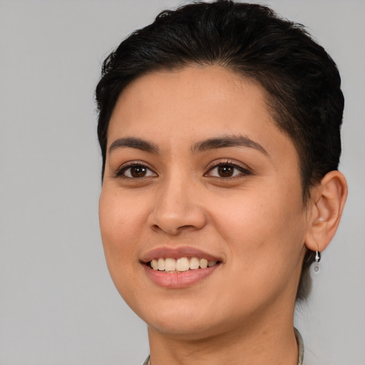 Joyful latino young-adult female with short  black hair and brown eyes