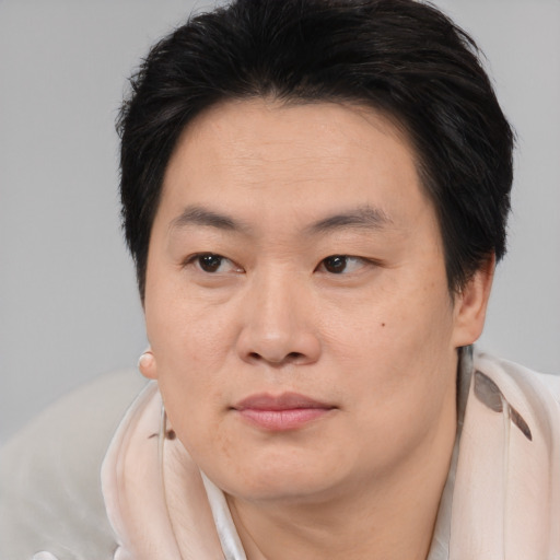 Joyful asian young-adult male with medium  brown hair and brown eyes