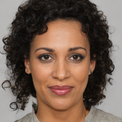 Joyful latino adult female with medium  brown hair and brown eyes