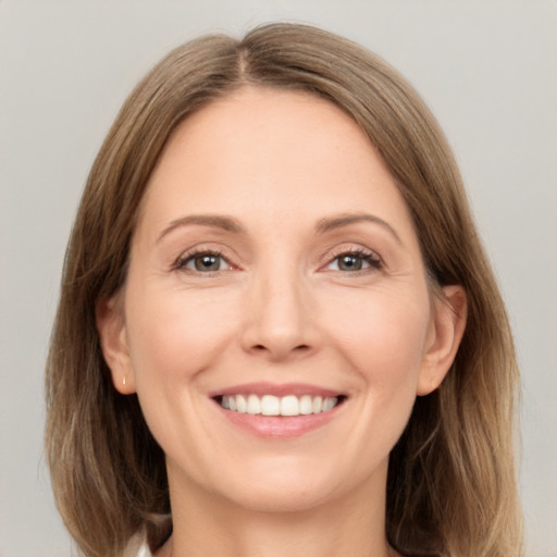 Joyful white adult female with medium  brown hair and grey eyes