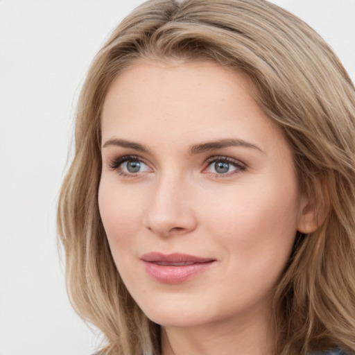 Joyful white young-adult female with long  brown hair and blue eyes