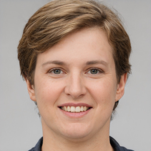 Joyful white young-adult female with short  brown hair and grey eyes