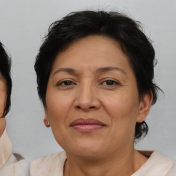 Joyful latino adult female with medium  brown hair and brown eyes