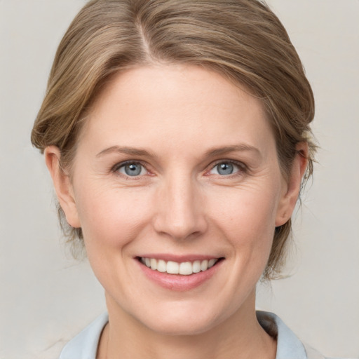 Joyful white young-adult female with medium  brown hair and blue eyes