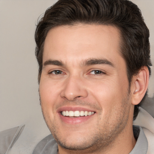 Joyful white young-adult male with short  brown hair and brown eyes