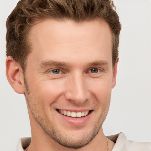 Joyful white young-adult male with short  brown hair and grey eyes