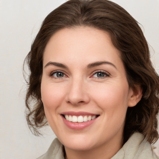 Joyful white young-adult female with medium  brown hair and green eyes