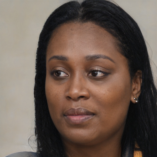 Joyful black young-adult female with long  black hair and brown eyes