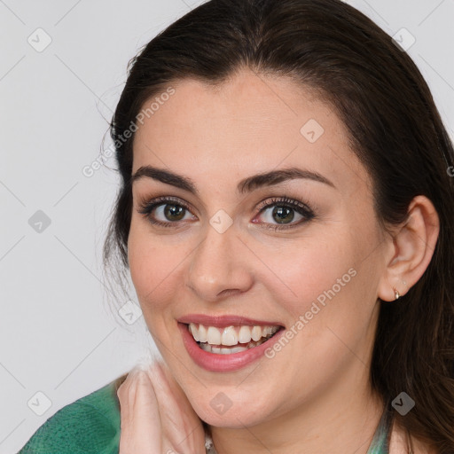 Joyful white young-adult female with long  brown hair and brown eyes