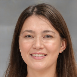 Joyful white adult female with long  brown hair and brown eyes