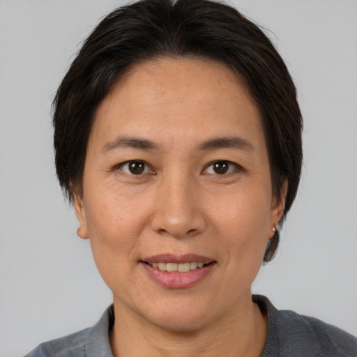 Joyful asian adult female with medium  brown hair and brown eyes