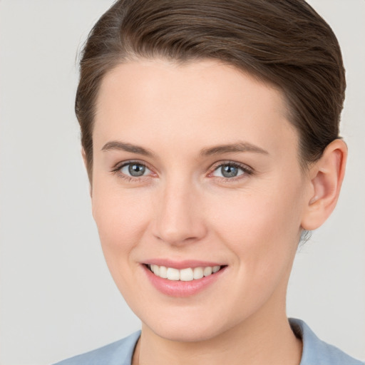 Joyful white young-adult female with short  brown hair and grey eyes