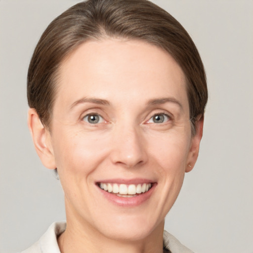 Joyful white young-adult female with short  brown hair and grey eyes