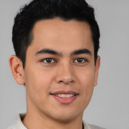 Joyful latino young-adult male with short  brown hair and brown eyes