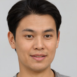 Joyful asian young-adult male with short  brown hair and brown eyes