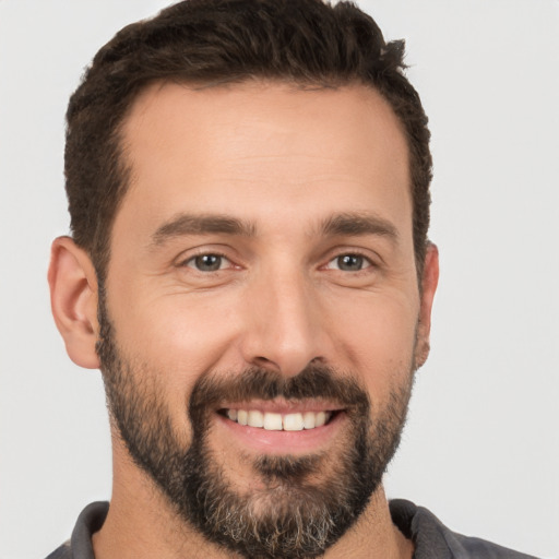 Joyful white young-adult male with short  black hair and brown eyes