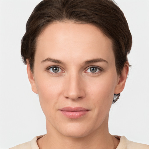 Joyful white young-adult female with short  brown hair and grey eyes