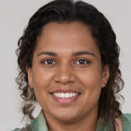 Joyful black adult female with medium  brown hair and brown eyes