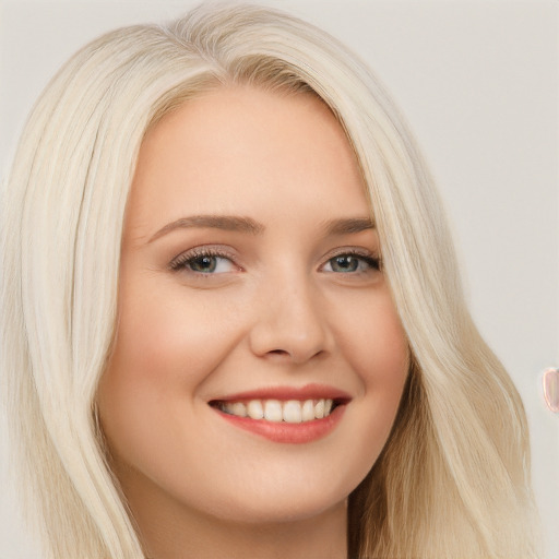 Joyful white young-adult female with long  blond hair and blue eyes