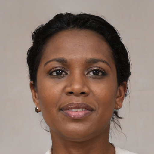 Joyful black young-adult female with short  black hair and brown eyes