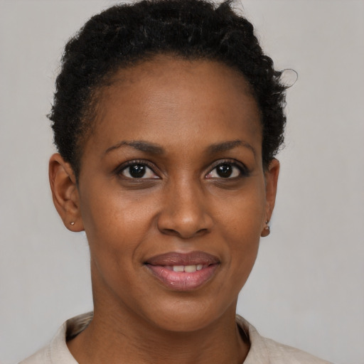 Joyful black adult female with short  black hair and brown eyes