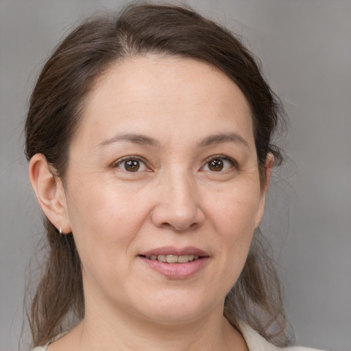 Joyful white adult female with medium  brown hair and brown eyes