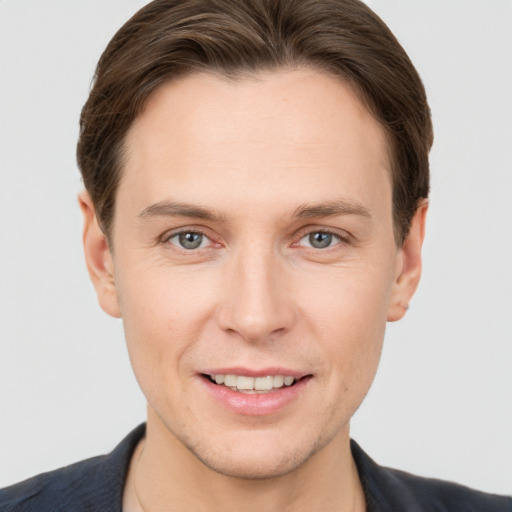 Joyful white young-adult male with short  brown hair and grey eyes