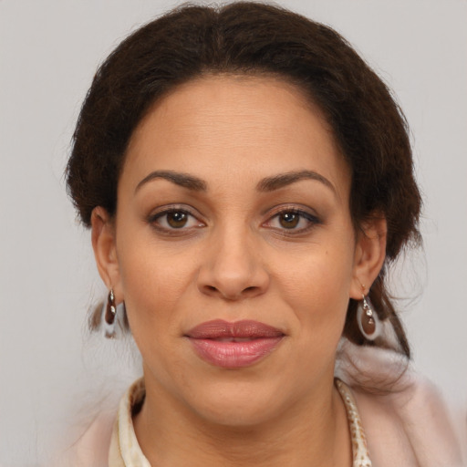 Joyful latino adult female with medium  brown hair and brown eyes