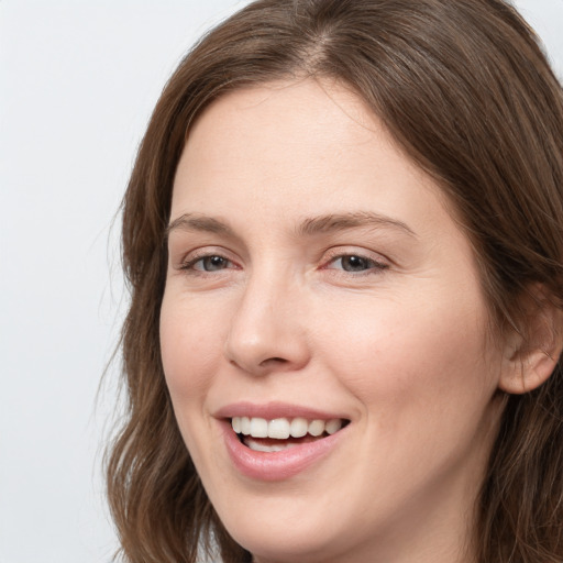 Joyful white young-adult female with long  brown hair and grey eyes