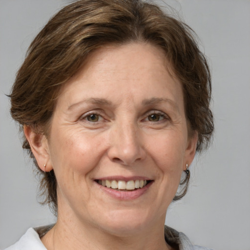 Joyful white adult female with medium  brown hair and grey eyes