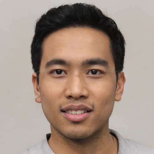Joyful asian young-adult male with short  black hair and brown eyes