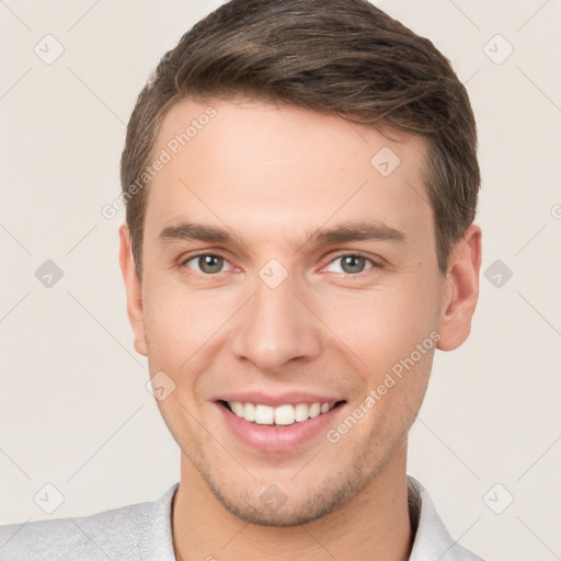 Joyful white young-adult male with short  brown hair and grey eyes