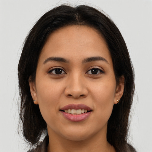 Joyful latino young-adult female with long  brown hair and brown eyes
