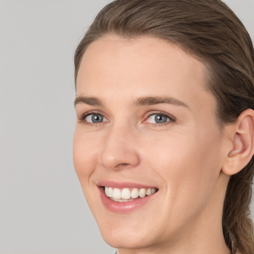 Joyful white young-adult female with long  brown hair and grey eyes