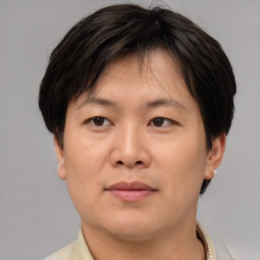 Joyful asian adult female with short  brown hair and brown eyes