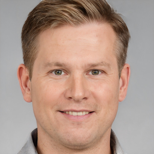 Joyful white adult male with short  brown hair and grey eyes