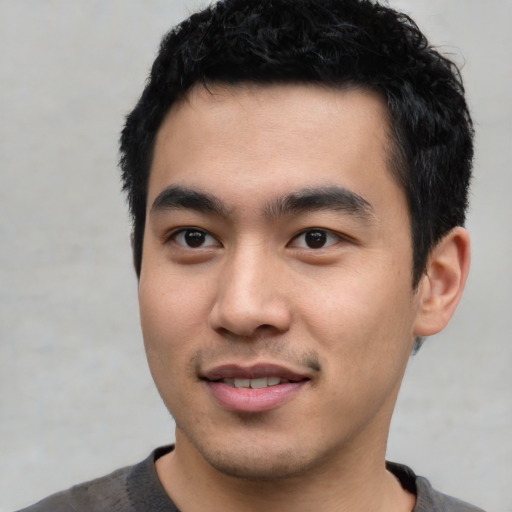 Joyful asian young-adult male with short  black hair and brown eyes