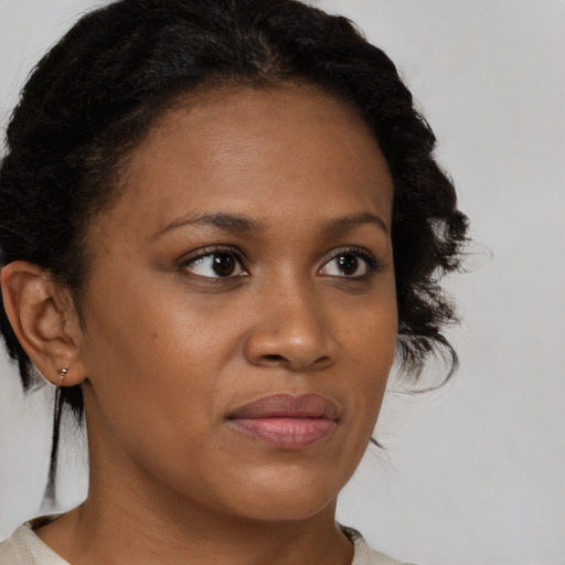 Joyful black young-adult female with medium  brown hair and brown eyes