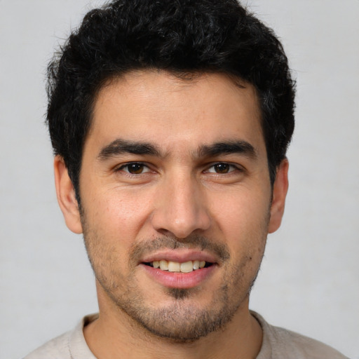 Joyful white young-adult male with short  black hair and brown eyes